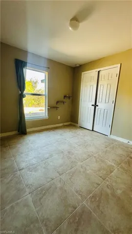 Unfurnished bedroom featuring baseboards and a closet