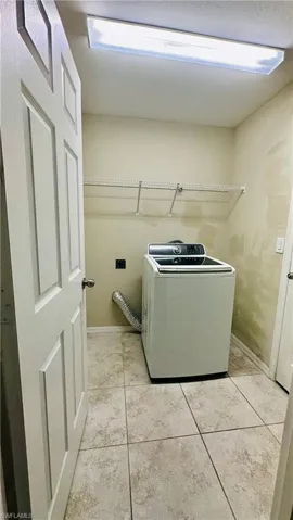 Laundry area featuring washer / clothes dryer and light tile patterned floors
