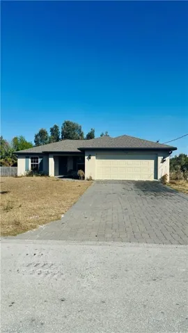 Ranch-style home featuring stucco siding, driveway, an attached garage, and a shingled roof