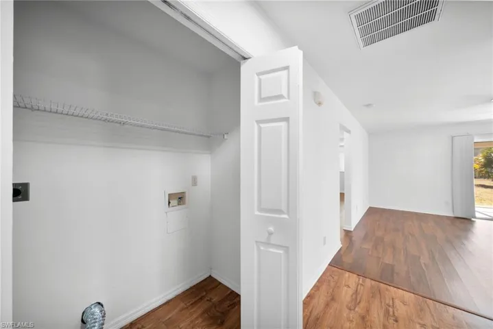 Laundry area featuring dark wood-style flooring, washer hookup, and electric dryer hookup
