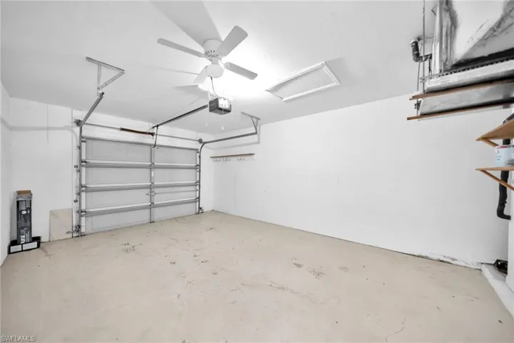 Garage featuring ceiling fan and a garage door opener