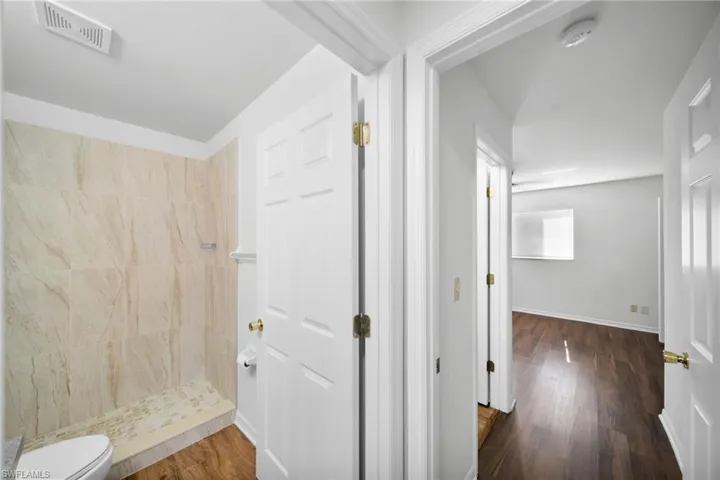 Hall featuring dark wood finished floors and baseboards