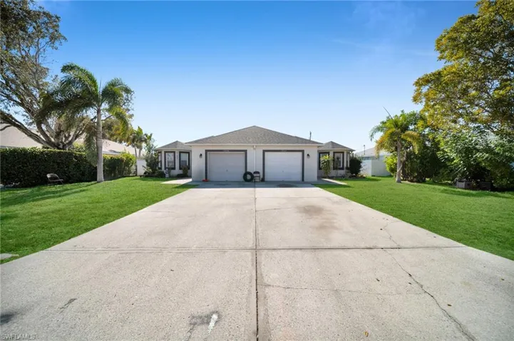 Ranch-style home featuring a front yard, driveway, and a garage