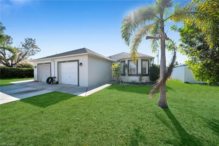 Ranch-style home featuring stucco siding, concrete driveway, an attached garage, and roof with shingles