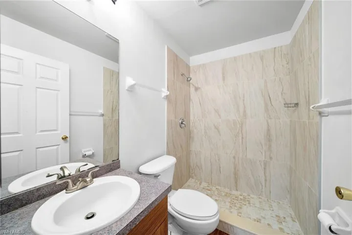 Full bathroom featuring a tile shower and vanity