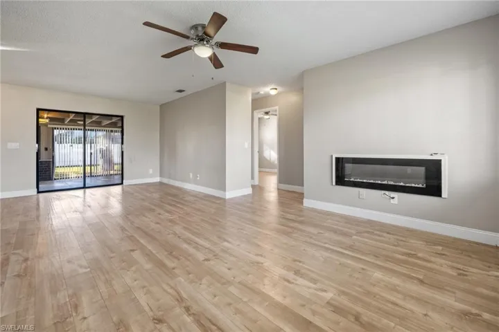 Unfurnished living room featuring ceiling fan, a textured ceiling, and light wood-type flooring
