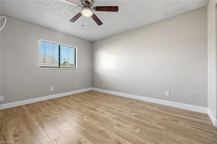 Spare room with ceiling fan, a textured ceiling, and light hardwood / wood-style flooring