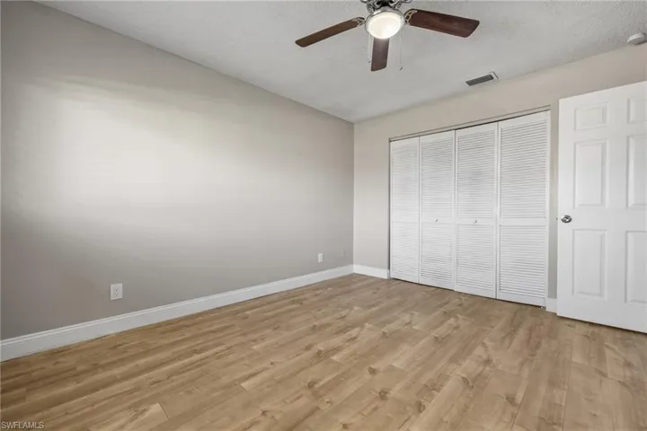 Unfurnished bedroom with a textured ceiling, light wood-type flooring, and ceiling fan