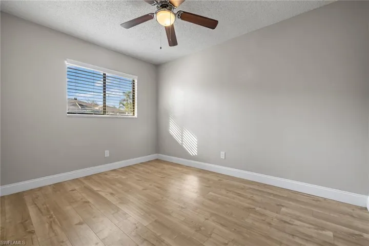 Unfurnished room featuring light hardwood / wood-style floors, a textured ceiling, and ceiling fan