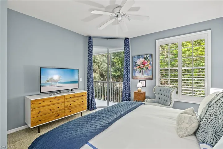 Bedroom featuring multiple windows, access to outside, and ceiling fan