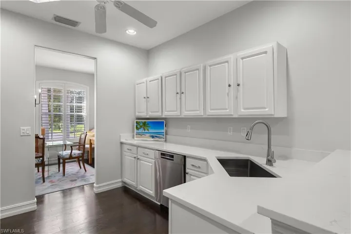 Kitchen with dishwasher, sink, ceiling fan, white cabinets, and dark hardwood / wood-style floors