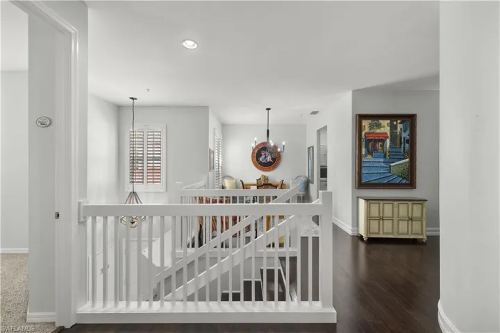 Hallway with a notable chandelier and dark wood-type flooring