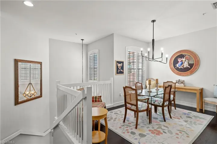 Dining area with a chandelier, dark wood-type flooring, and a wealth of natural light