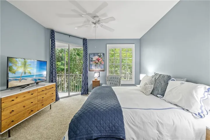 Bedroom featuring access to outside, multiple windows, carpet floors, and ceiling fan