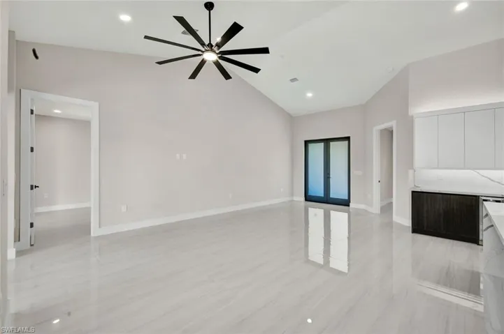 Unfurnished living room featuring recessed lighting, high vaulted ceiling, and ceiling fan