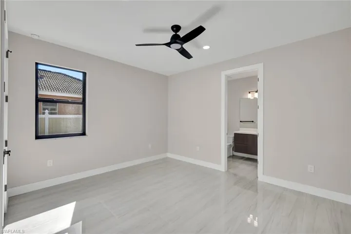 Unfurnished bedroom featuring ceiling fan, ensuite bathroom, and recessed lighting
