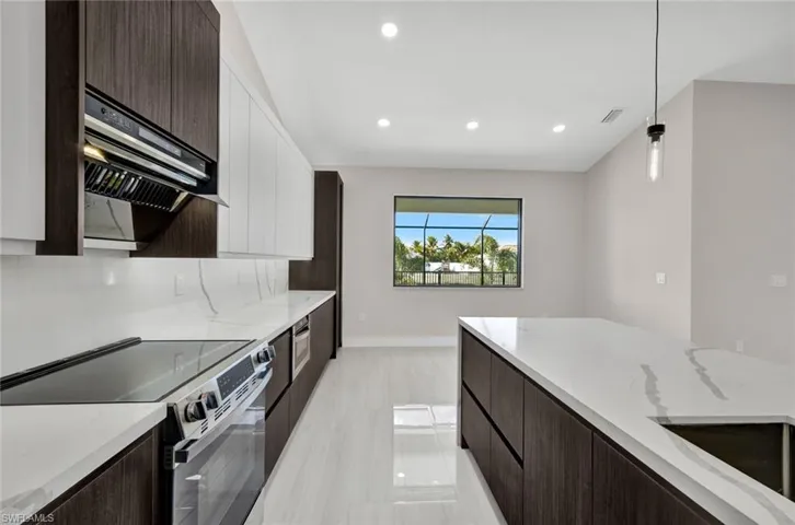Kitchen featuring dark brown cabinets, modern cabinets, stainless steel electric range, light stone countertops, and recessed lighting