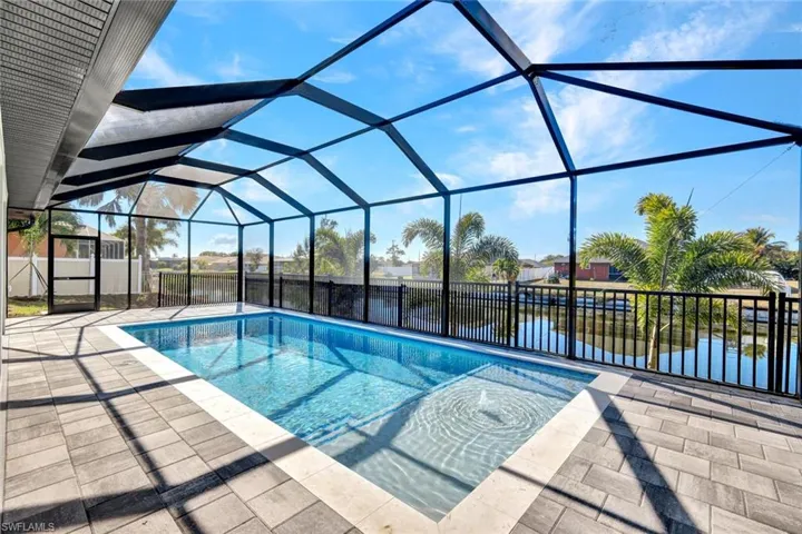 View of swimming pool with a sunroom, a lanai, a patio, and a water view