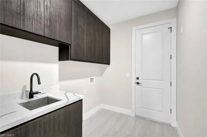 Washroom featuring washer hookup and cabinet space