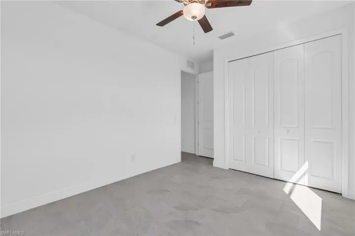 Unfurnished bedroom featuring light tile patterned floors, a closet, and ceiling fan