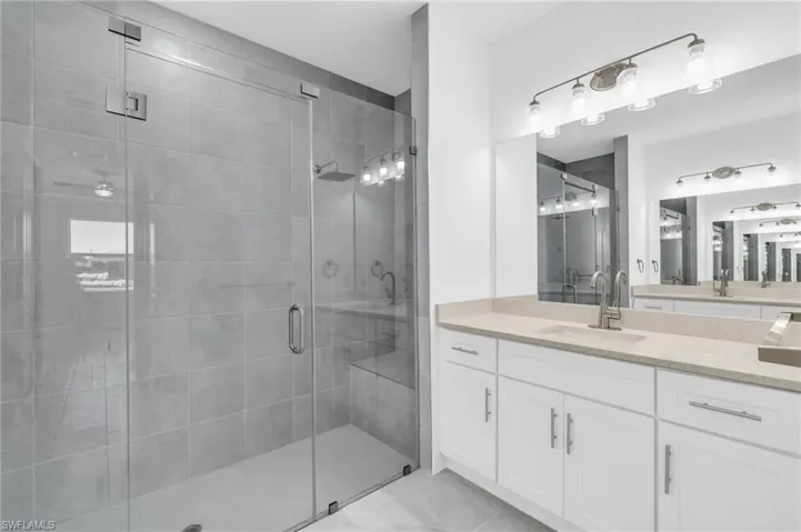 Bathroom featuring vanity and a shower with door