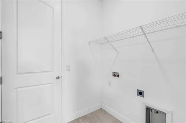 Laundry room with washer hookup, light tile patterned floors, and electric dryer hookup
