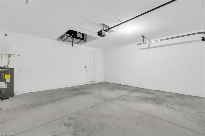 Garage with electric water heater and a garage door opener