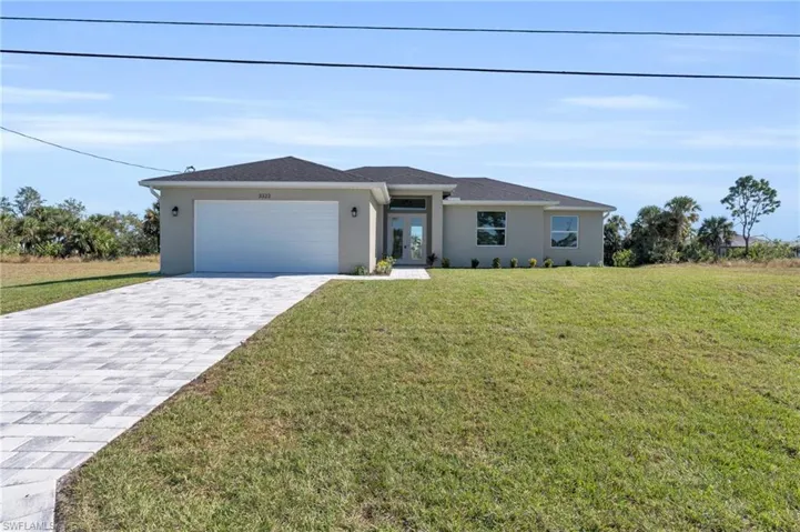 View of front of house with a garage and a front lawn