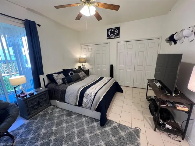Bedroom with ample closet space and ceiling fan.