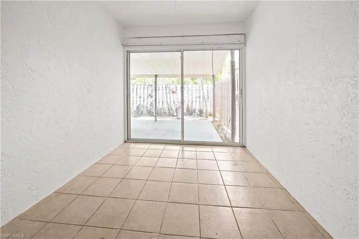 Interior space featuring textured walls, square tile flooring, and sliding glass doors