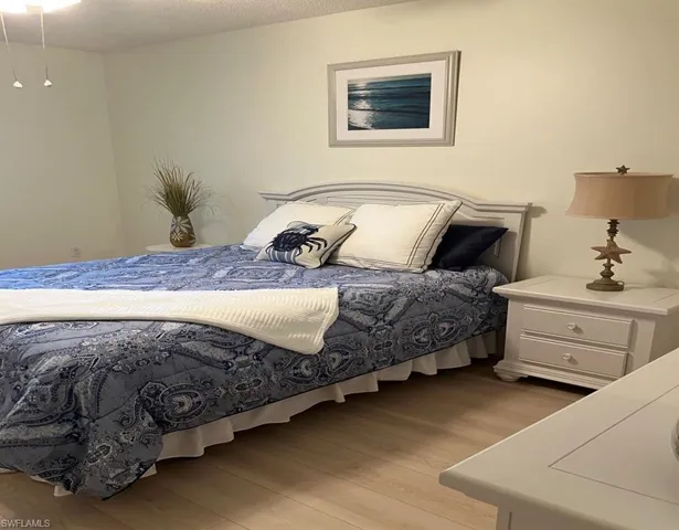 Bedroom featuring a textured ceiling and light hardwood / wood-style flooring