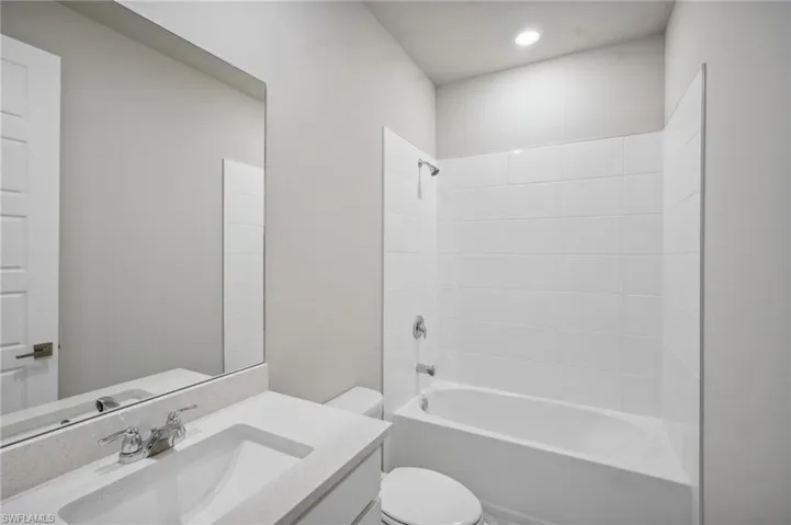 Full bathroom featuring vanity, shower / bath combination, and toilet