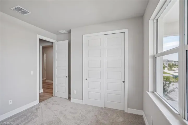 Unfurnished bedroom featuring a closet and light colored carpet