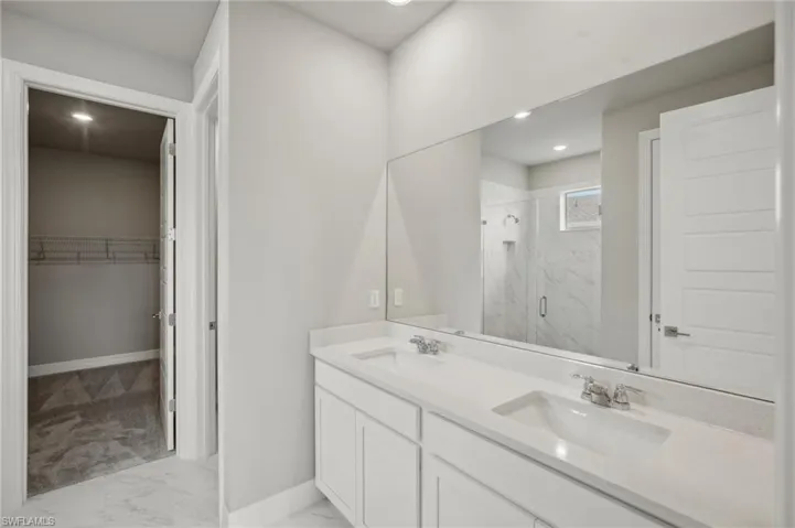 Bathroom featuring walk in shower and vanity