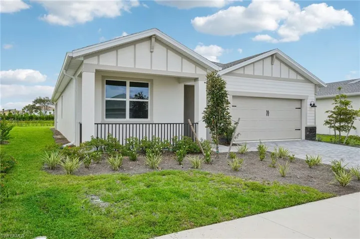 View of front of property with a front yard and a garage