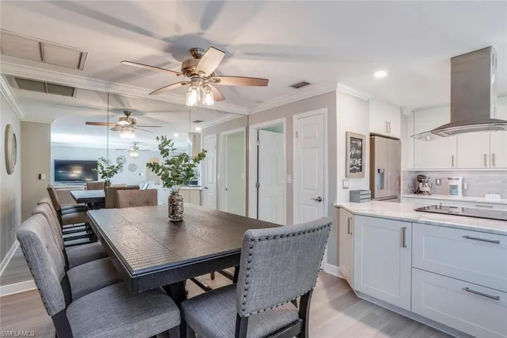 Full bath featuring vanity, tasteful backsplash, wood finished floors, a spacious closet, and crown molding
