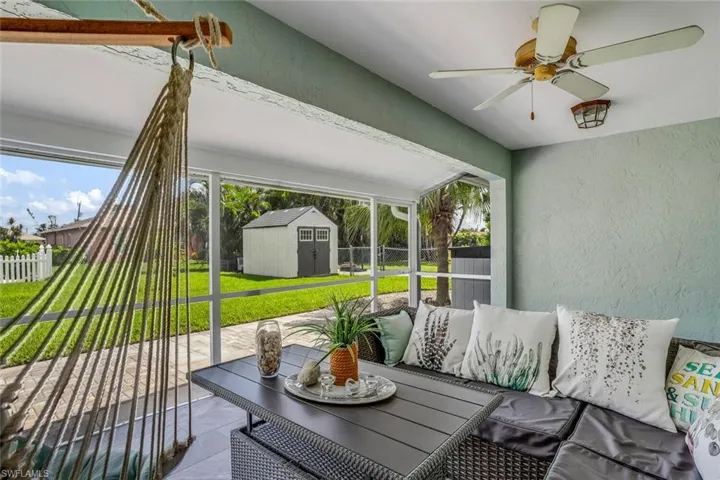 Rear view of property featuring a sunroom, a fenced backyard, and stucco siding
