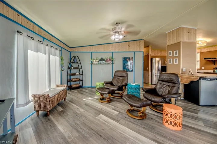Sitting room featuring vaulted ceiling, ceiling fan, and wood finished floors