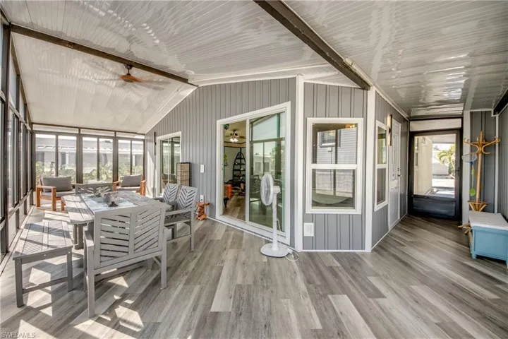 Sunroom / solarium featuring ceiling fan, vaulted ceiling, and outdoor dining area