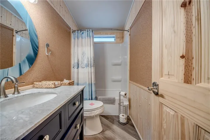 Bathroom featuring vanity, light wood-style floors, and shower / tub combo