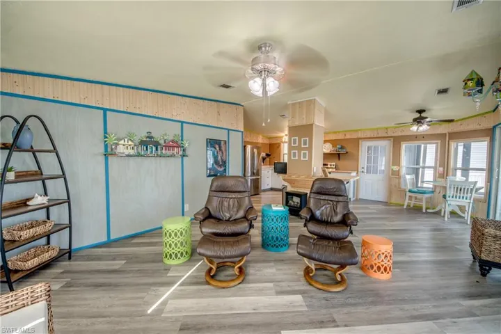 Living room featuring wood finished floors, ceiling fan, and wooden walls