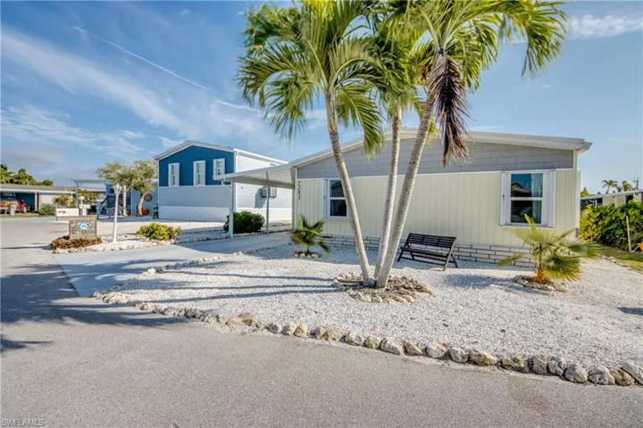 Manufactured / mobile home featuring a carport and driveway