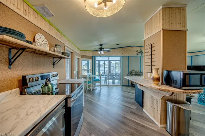 Kitchen with open shelves, appliances with stainless steel finishes, dark wood finished floors, ceiling fan, and wooden counters