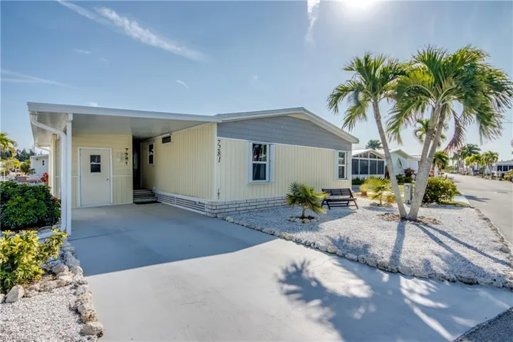 Manufactured / mobile home with a carport, concrete driveway, and entry steps