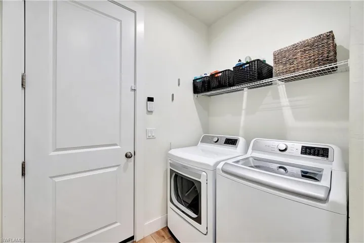 Washroom with independent washer and dryer and light hardwood / wood-style floors