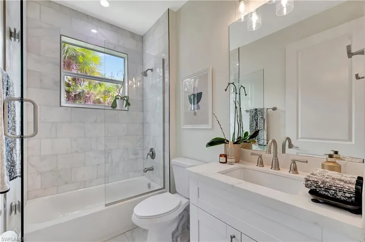 Full bathroom featuring vanity, shower / bath combination with glass door,