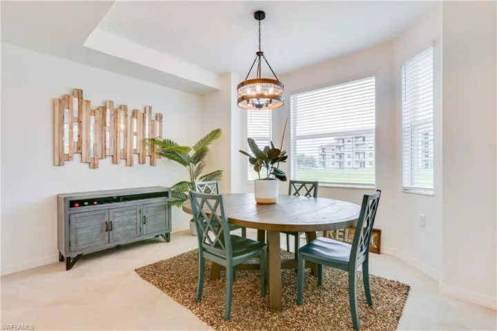 Dining area with light tile patterned floors and a chandelier