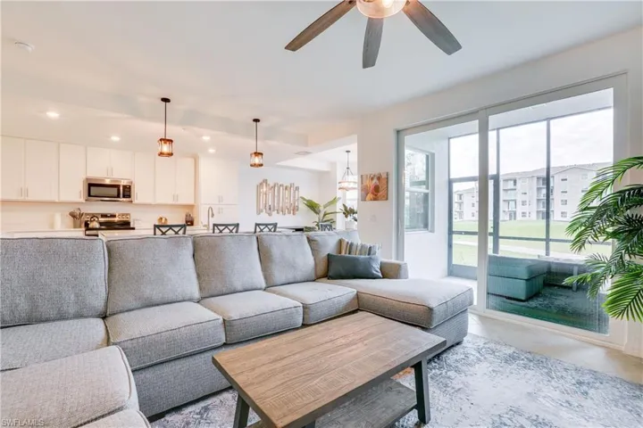 Living area with recessed lighting, light tile patterned floors, and a ceiling fan