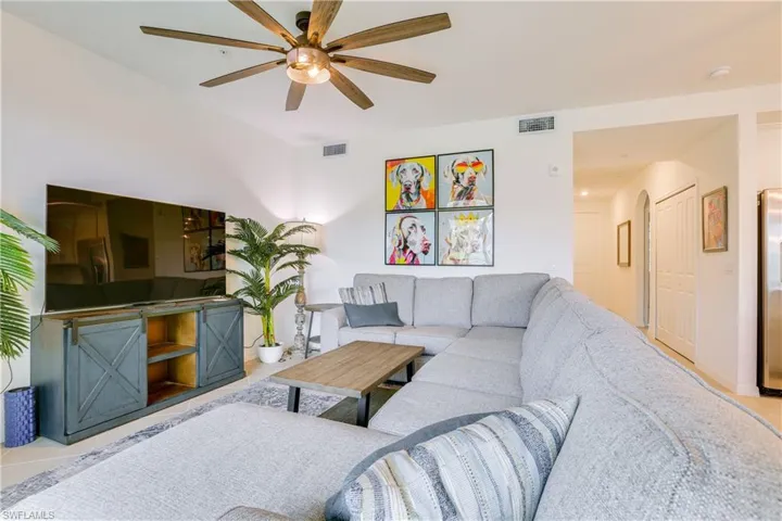 Living area featuring a ceiling fan and light tile patterned floors