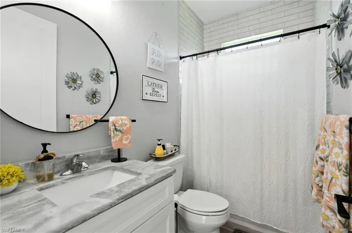 Full bath with vanity and a shower with shower curtain